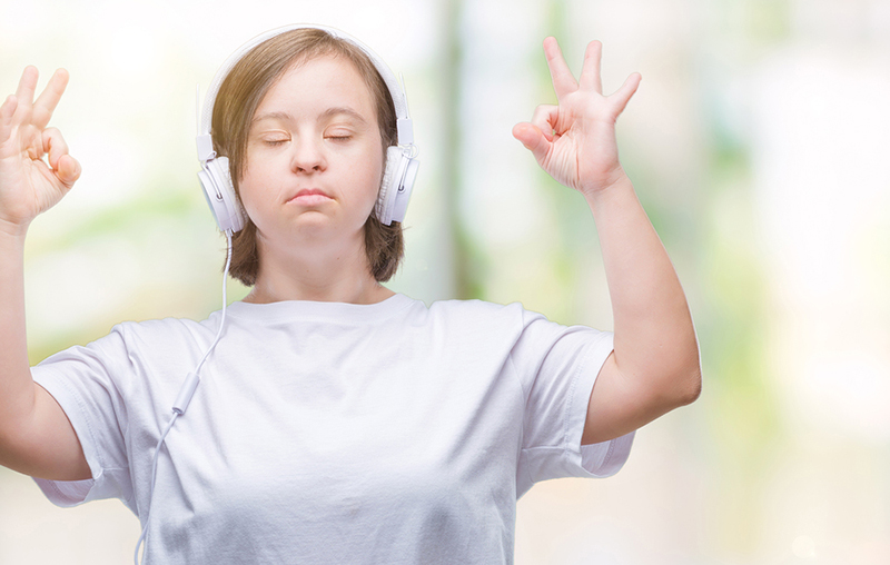 Calm woman meditating with headphones on.